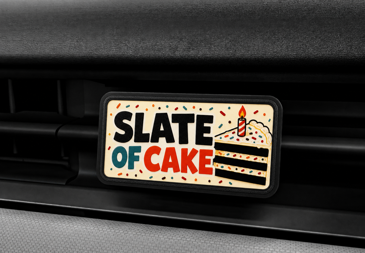 Close-up of the Slate of Cake RadPaul Dash Badge mounted in a Slate pickup dashboard vent