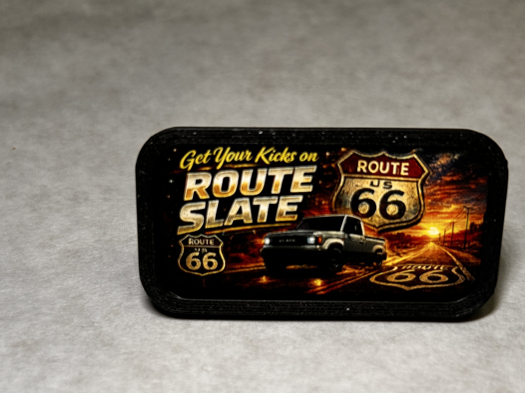 Centered close-up front view of the reusable clip in The Highway Pack with the Route 66 sticker installed
