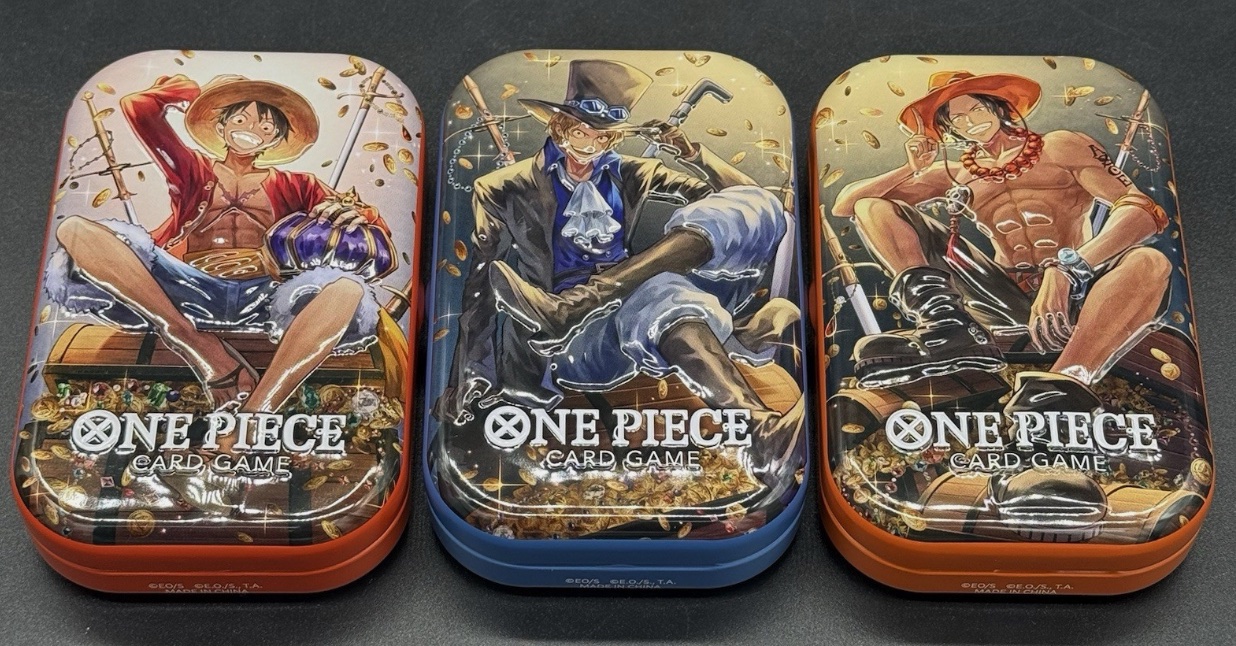 Three rectangular One Piece Card Game metal tins with illustrated lids