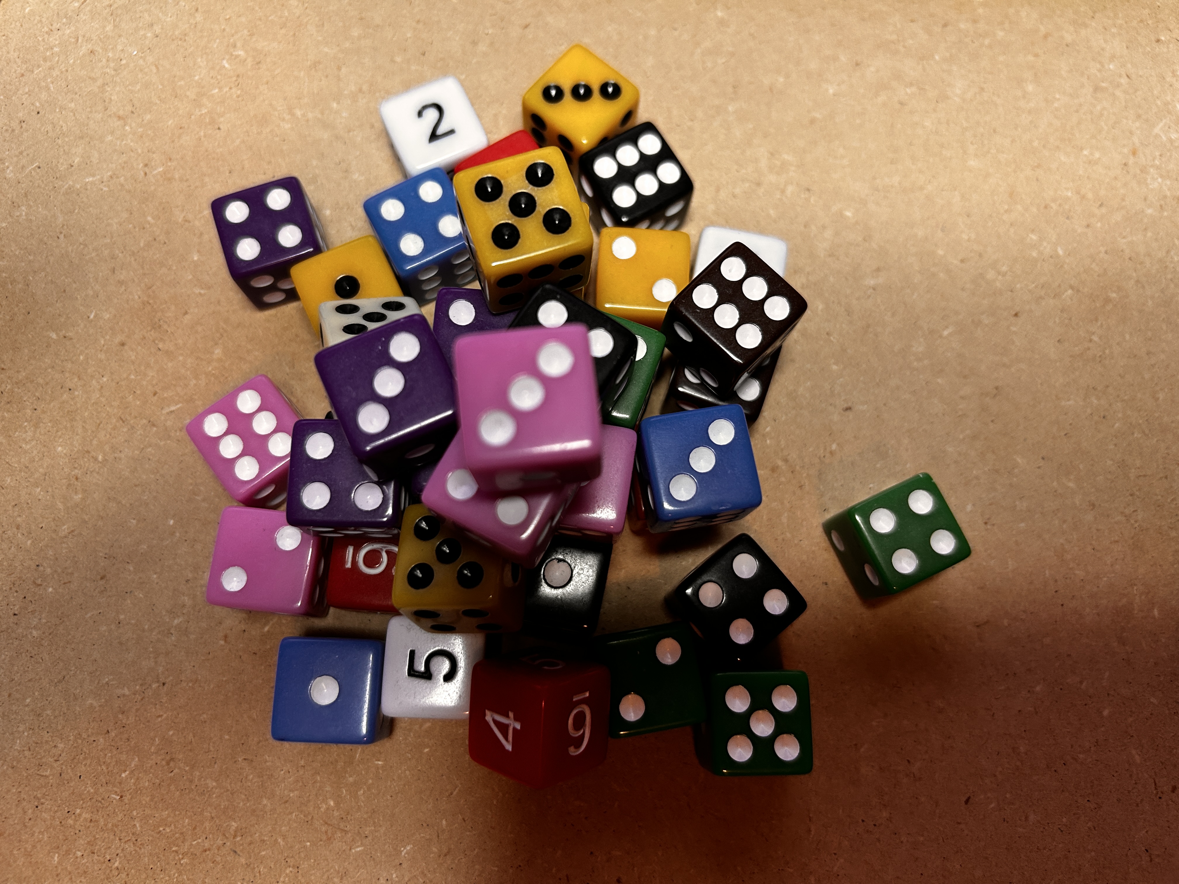 Colorful standard six-sided dice used as a sizing reference